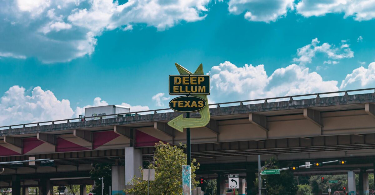 Vibrant street scene of Deep Ellum Texas with iconic sign under an overpass in Dallas
