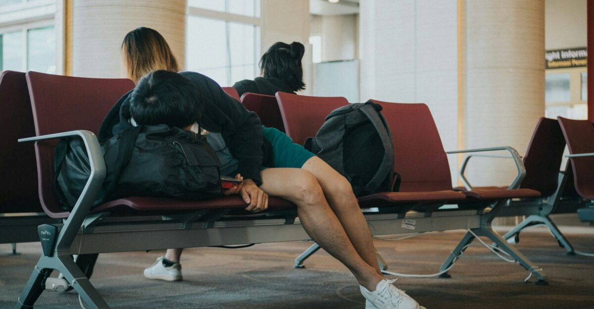 unknown person lying on brown bench indoors