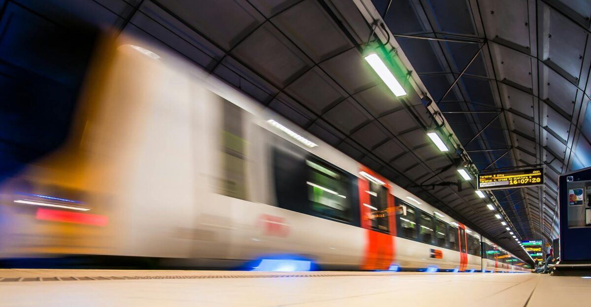 Blurred image of a train rushing through an indoor subway station in Longford UK