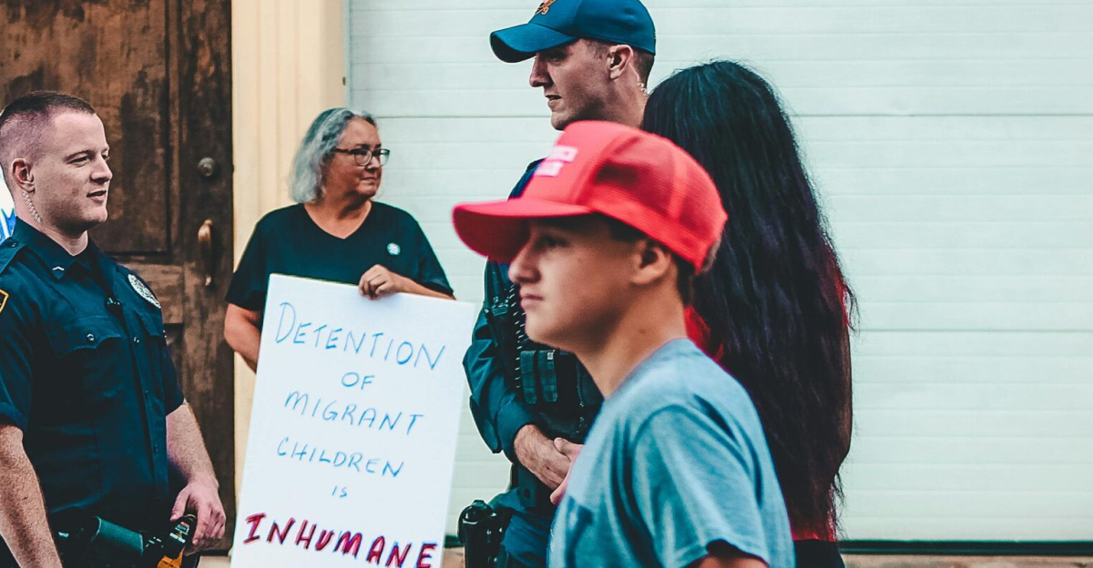 Street protest in Wheeling, WV highlighting immigration issues with signs and police presence.