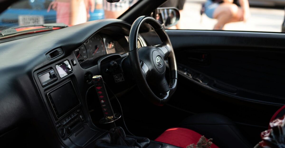 Close-up of a Toyota car s interior showing the steering wheel dashboard and manual gear shift