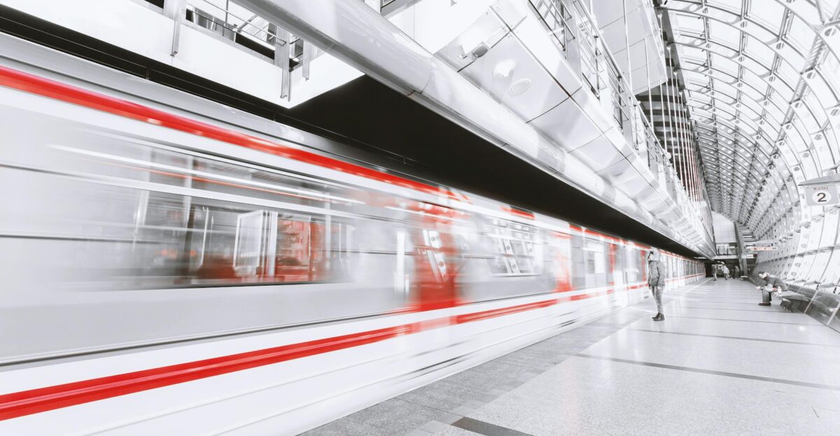 Blurred high-speed train in a sleek modern station capturing urban commuting and motion