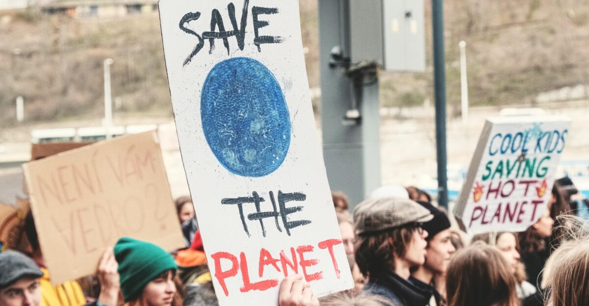 A climate change protest in Prague with people holding environmental signs like Save the Planet