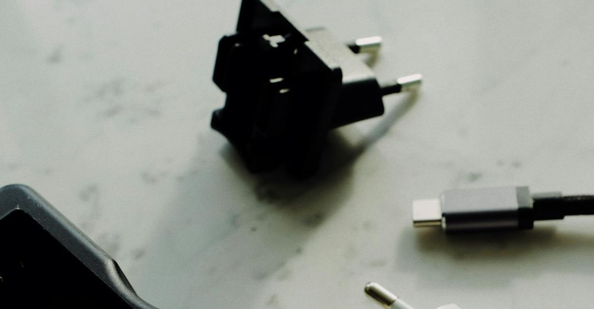 A flat lay of various electronic chargers and adapters on a marble surface