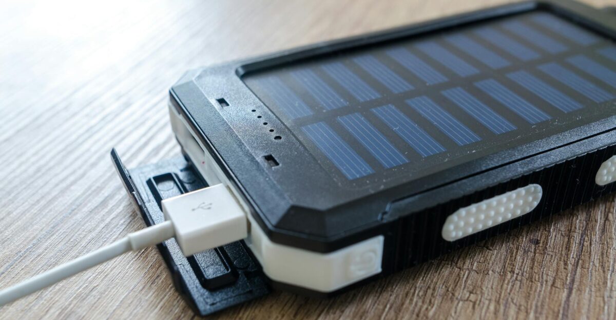 A close-up of a solar charger with a USB connection on a wooden surface showcasing modern technology