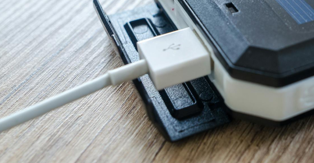 A close-up of a solar charger with a USB connection on a wooden surface showcasing modern technology