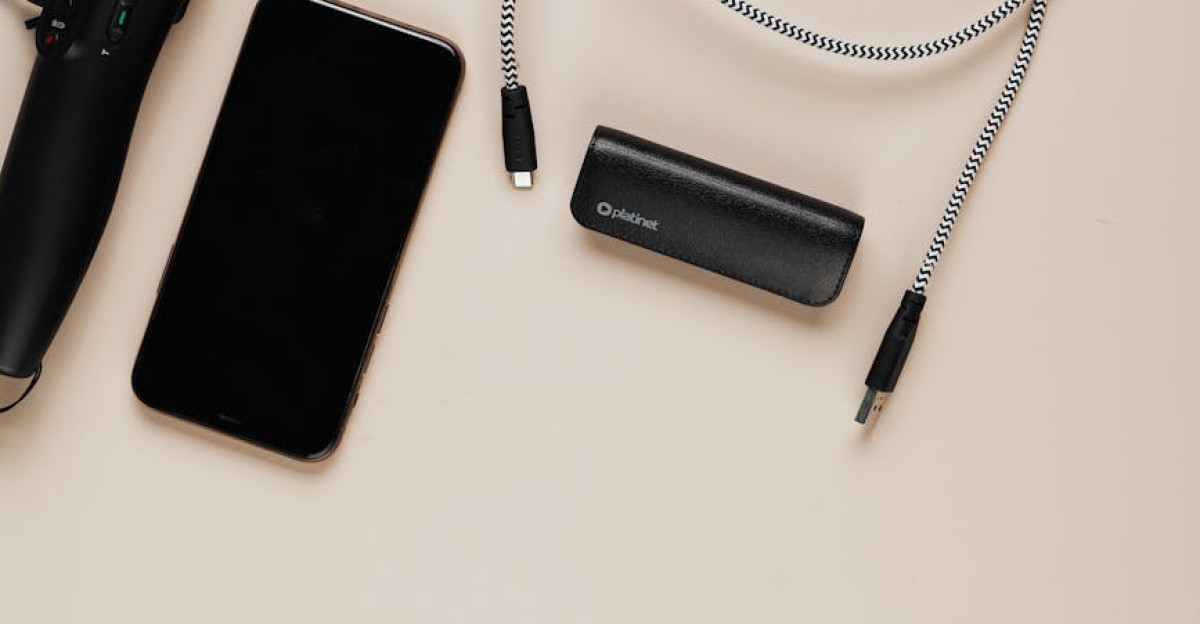 Minimalist flat lay featuring a smartphone gimbal charging cables and power bank on a beige background