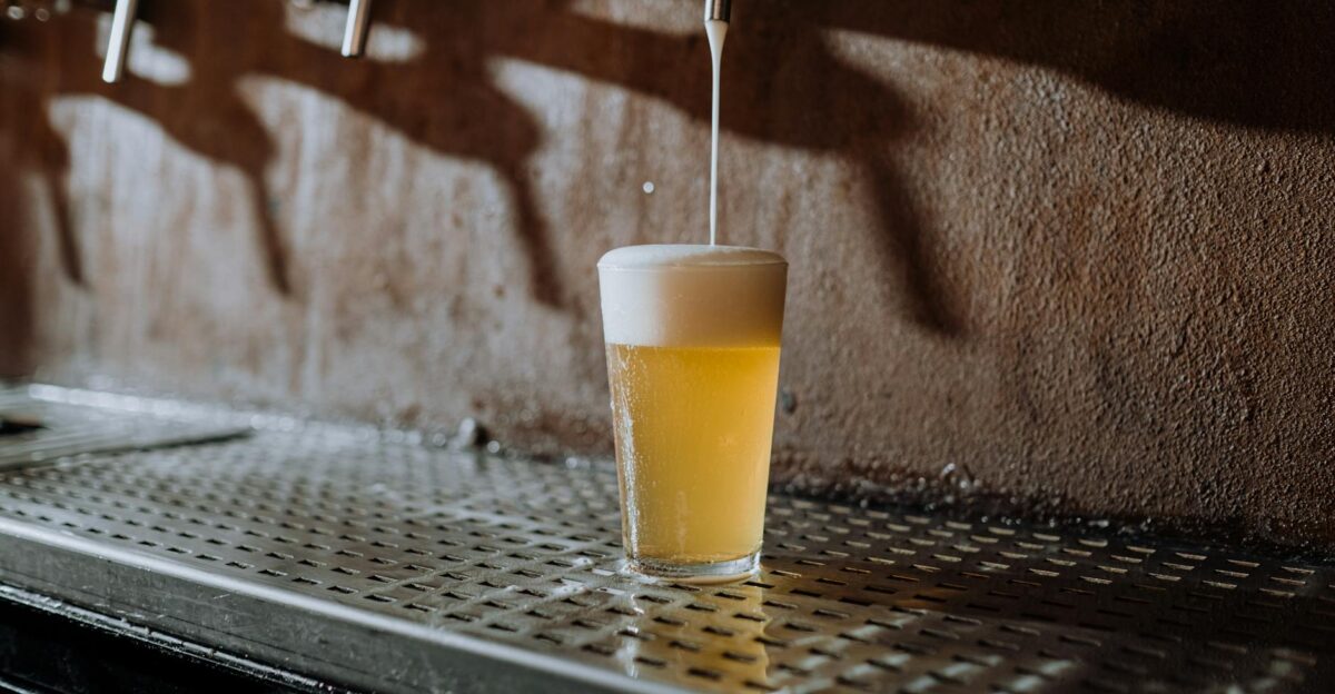 A glass of refreshing cold beer being poured from a tap in a cozy bar setting