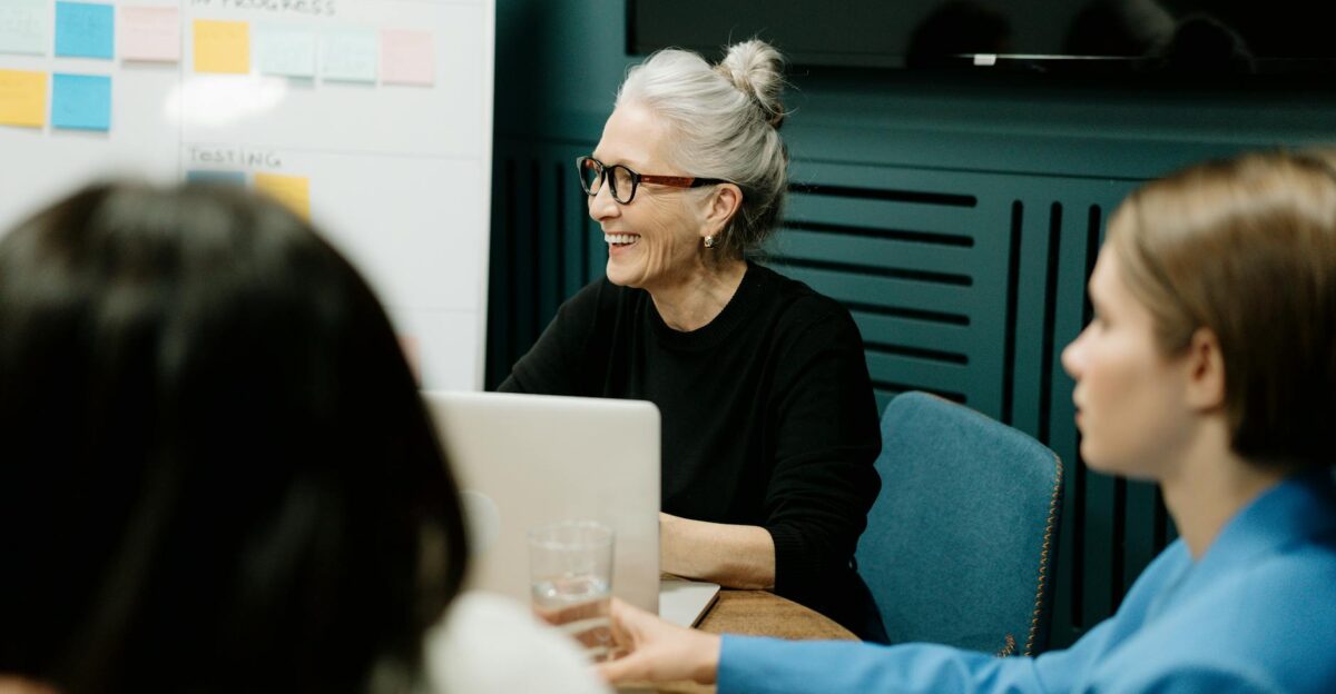 Smiling senior businesswoman leading a diverse team meeting in an office