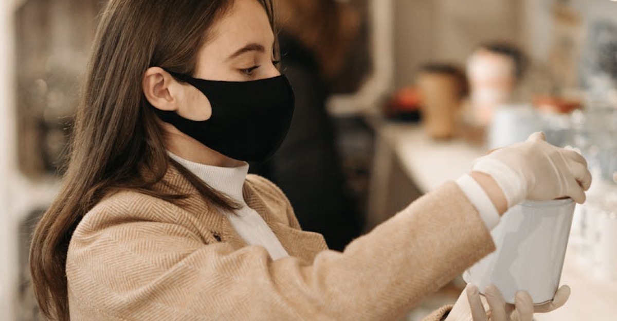 Woman wearing a coat mask and gloves shops for products indoors during the pandemic