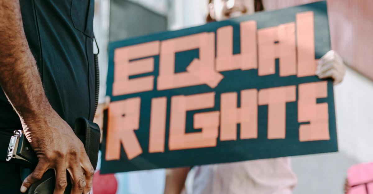 A group of protesters holding signs advocating for equal rights in city street.