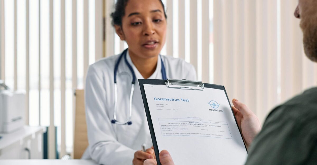 Doctor having a consultation with a patient over coronavirus test results in a medical office