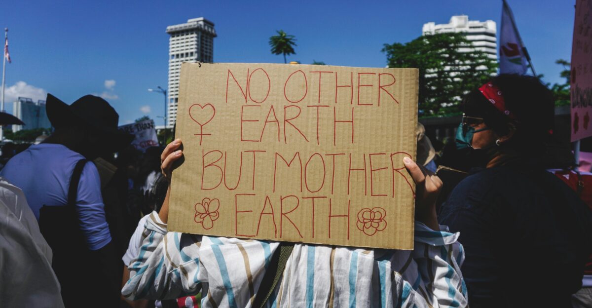 a group of people holding a sign that says no other earth but mother earth