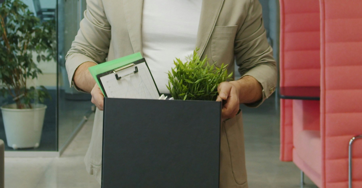 Man carrying box of belongings in office