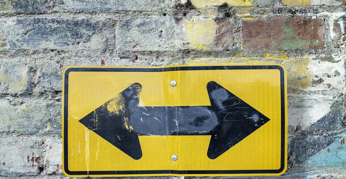Weathered yellow two-way street sign on a textured rustic brick wall Urban art style