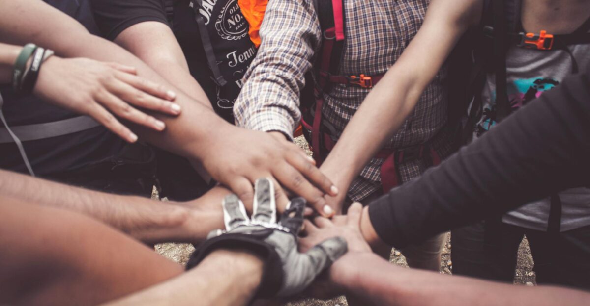 A group of diverse individuals join hands for teamwork in West Java Indonesia