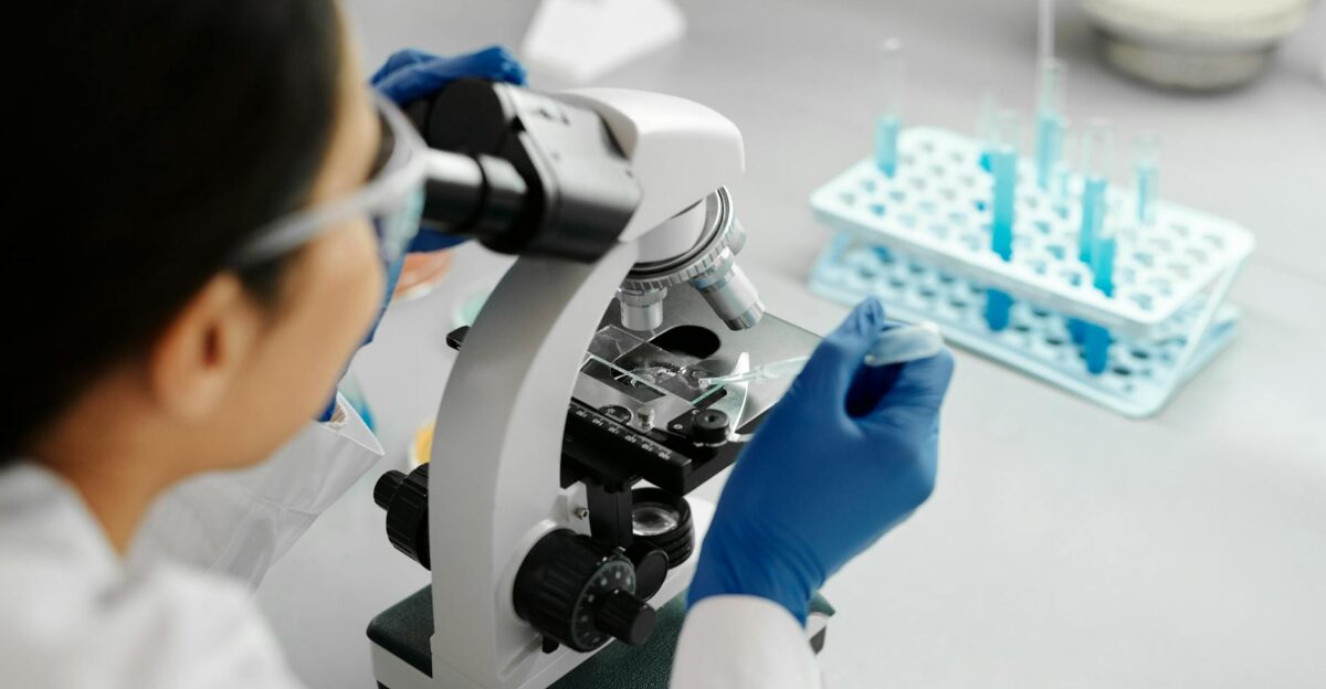 Scientist conducting research in a lab using a microscope and dropper