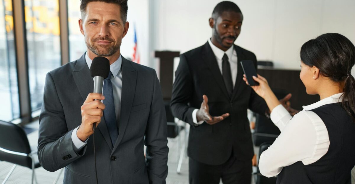 A journalist interviews a businessman in a conference room capturing a professional and political setting