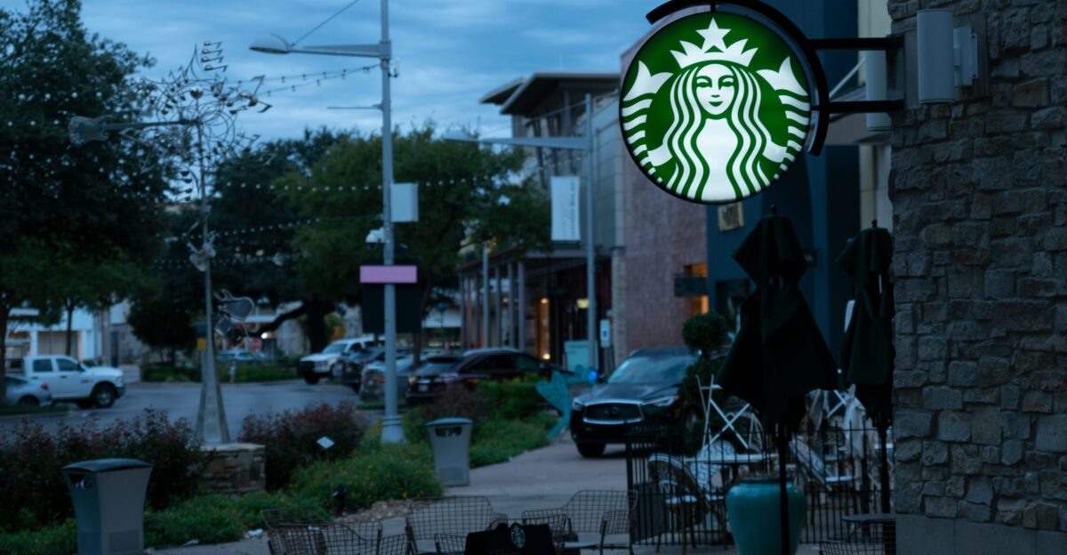a starbucks sign hanging from the side of a building