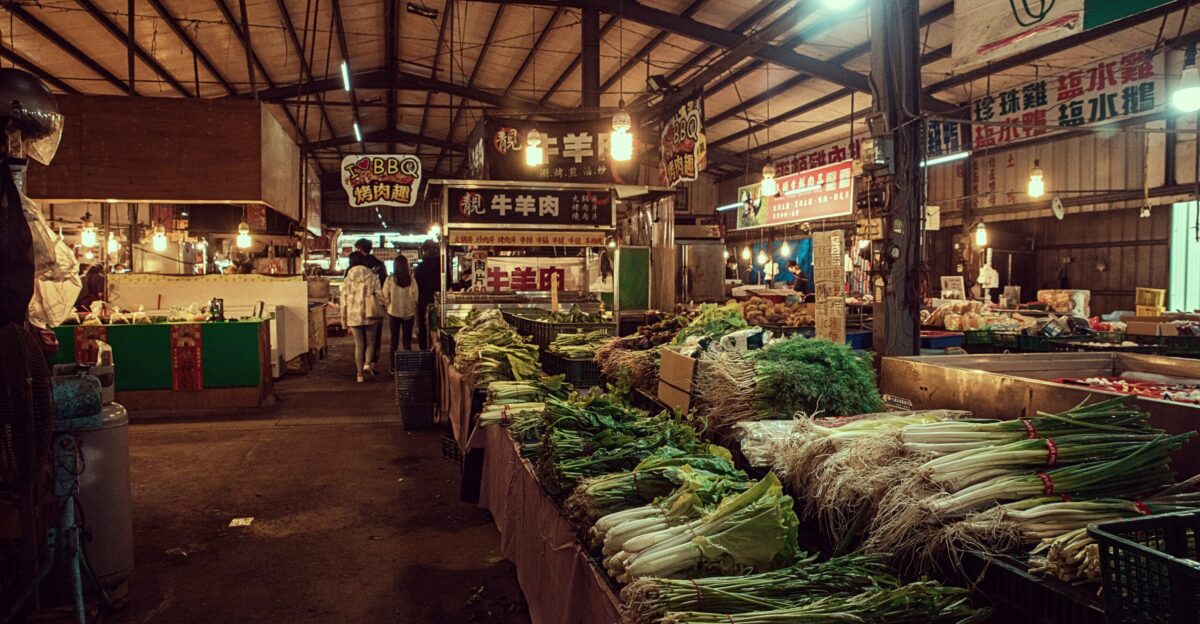 an indoor market with a variety of vegetables