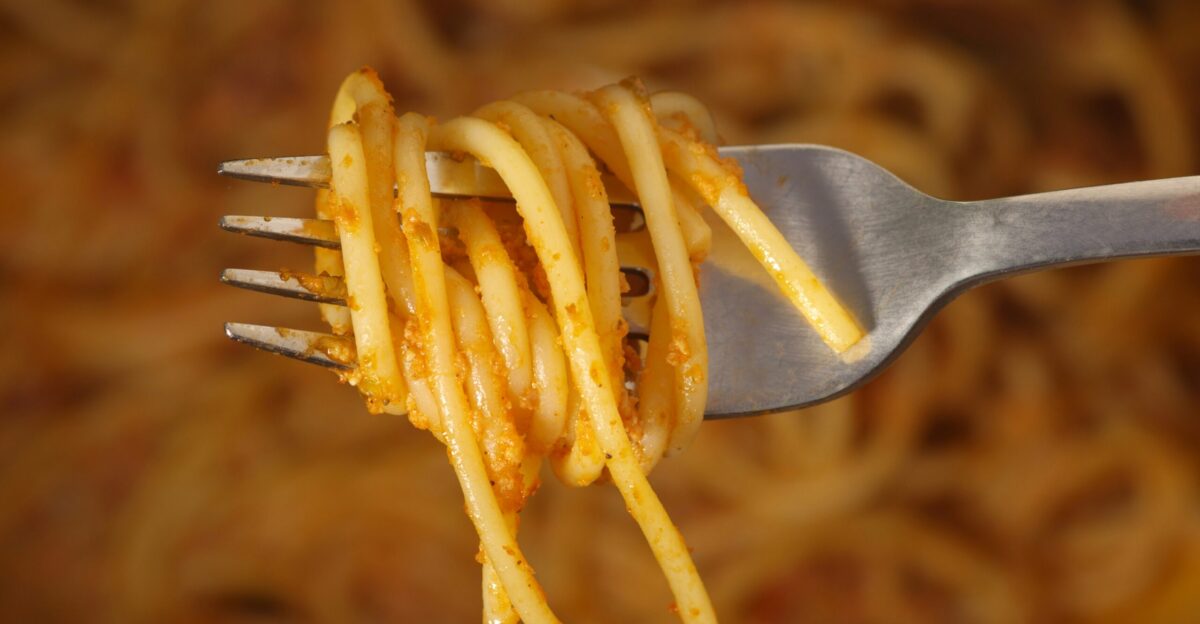 a fork full of spaghetti being held by a fork