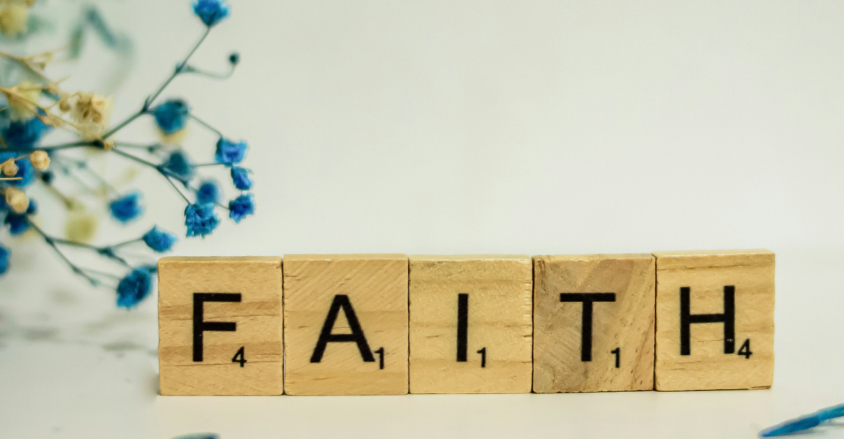 a wooden block that says faith next to blue flowers